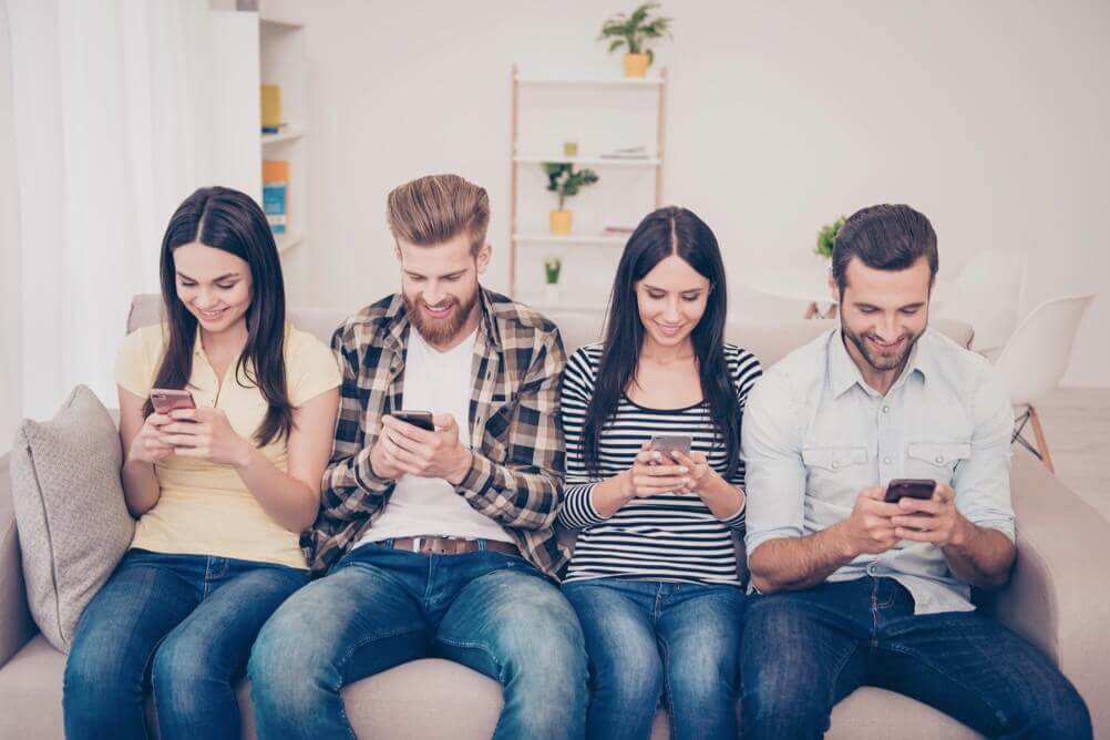 Cómo ganar la lotería haciendo jugadas múltiples Grupo de personas están sentadas en un sofa jugando la lotería con sus celulares