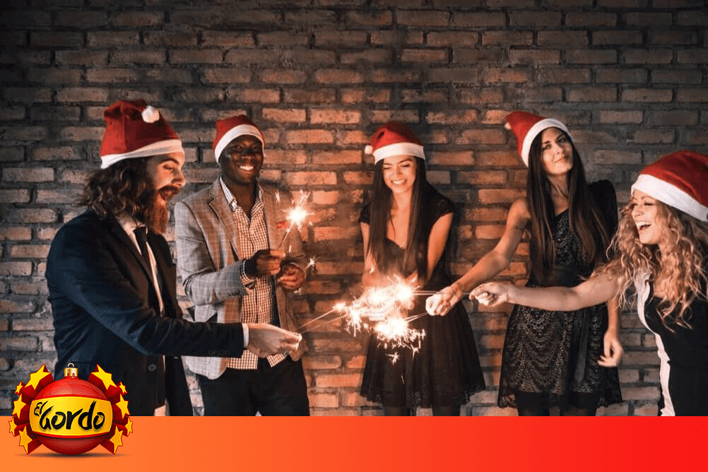 El gordo de navidad, los mayores premios de lotería Grupo de amigos usan gorros de navidad y encienden luces de bengala